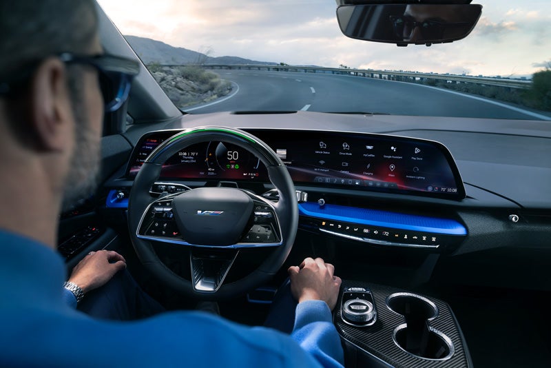 Front View of the 2026 OPTIQ-V Driving Through the Dusk Utilizing its Headlights | Jim Shorkey Cadillac in Gainesville GA